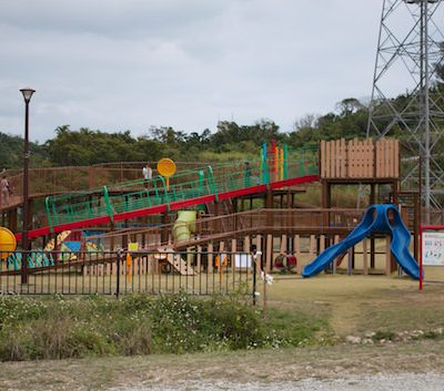 公園の遊具と電波塔のある風景の写真。